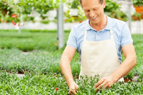 Gardener using equipment safely with hi-vis and protective gear